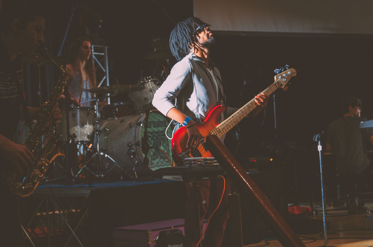 Dynamic live band performance featuring instruments and musicians on stage.