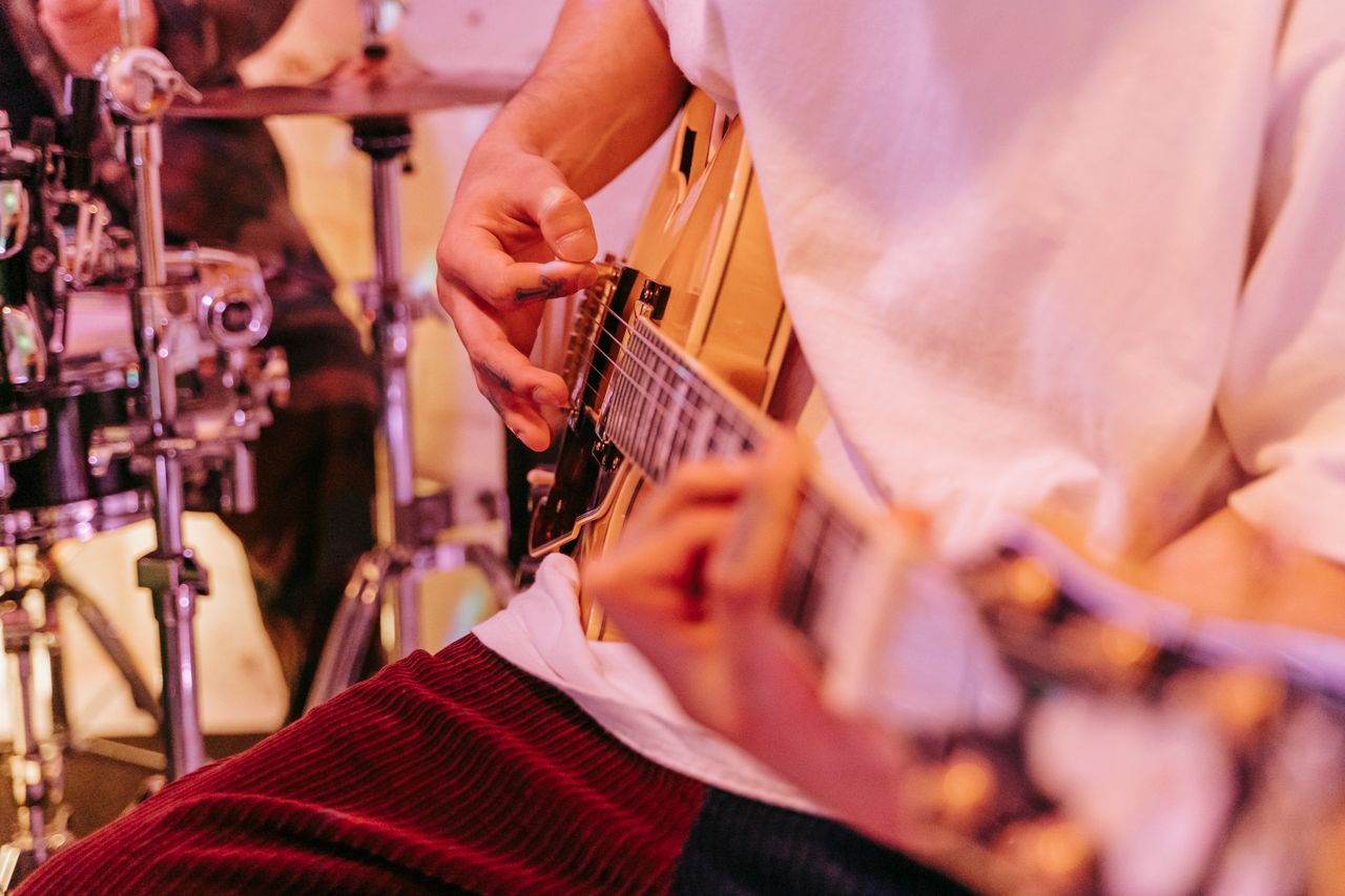 Close-up of a musician playing an electric guitar during a live performance.