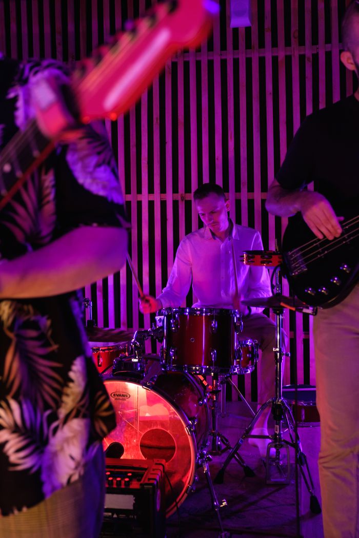 Vibrant live band performance featuring a drummer in an indoor setting with colorful lighting.